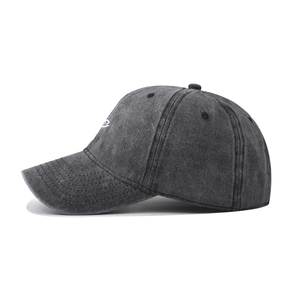 Detail of washed grey cotton baseball cap featuring side embroidery and precision stitching