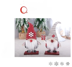 Close-up of two wooden Nordic Christmas gnomes with red and grey hats on festive bases