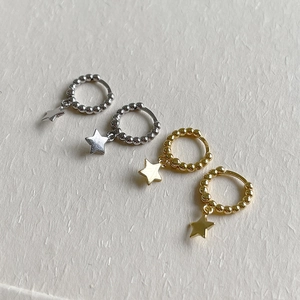 Detail of S925 sterling silver beaded hoop earrings with star charms in gold and silver