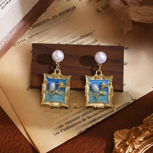 Macro view of vintage gold frame earring with 3D rose and pearl drop detail