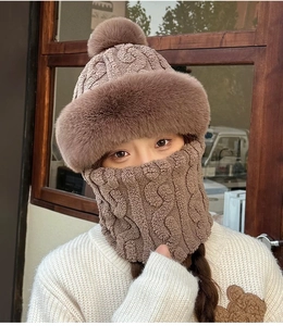 Close-up of the thick brown knit winter hat with fur pom-pom and matching neck warmer