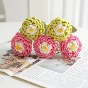 Detail showing multi-layer crochet pink and green flowers on a vintage newspaper background