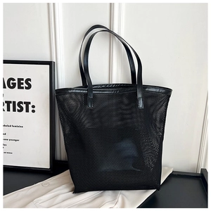 Close-up of black mesh beach tote with premium leather handles and trim detail