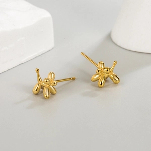 Minimalist golden balloon dog stud earrings on white geometric prop for women