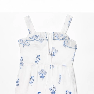 Weißes schulterfreies Maxikleid mit blauer Blumenstickerei und eleganten Rüschendetails