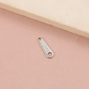 Macro shot of stainless steel tag with S.STEEL engraving for DIY jewelry making