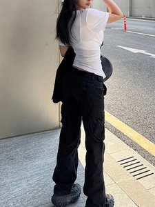 Detailed side view of black cargo pants with large flap pockets and a relaxed fit cut