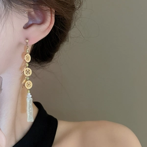 Detail of Chinese earrings with golden coin motif and green jade-style tassel