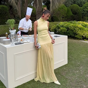 Dettaglio di un abito giallo senza maniche con gonna in tulle a pois in un giardino
