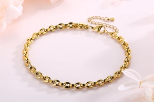 Detail der goldenen Edelstahl-Fußkette mit verstellbarem Karabinerverschluss und Verlängerung