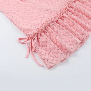 Détail d'une robe en dentelle rose avec bords à volants et cordon de serrage délicat
