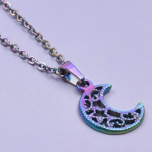 Macro detail of the iridescent stainless steel hollow moon pendant on a delicate chain