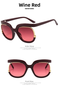 Detail of oversized wine red sunglasses with gold trim and pink gradient lenses