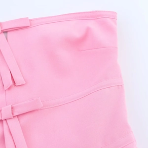 Detailed view of pink tube top showing fabric texture and a tied bow decoration