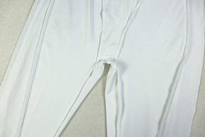 Detail of high-stretch white knitted fabric and reinforced crotch stitching on bodysuit