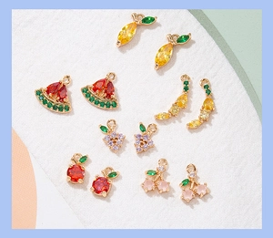 Macro view of colorful fruit charms with cubic zirconia on gold metal bases