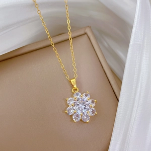 Close-up of sparkling sunflower pendant with clear zircons on gold titanium necklace