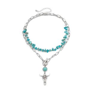 Detail of layered turquoise beaded chain and silver cow skull pendant with paperclip link