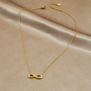 Elegant gold infinity symbol necklace in stainless steel on a champagne satin background