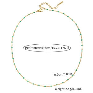 Detail of minimalist gold chain necklace with green enamel beads and adjustable clasp
