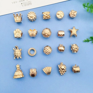 Detailed view of assorted KC gold alloy charms including crown and owl for DIY jewelry