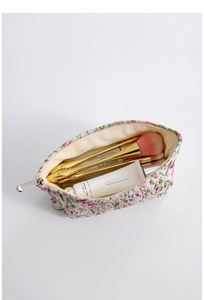 Detailed top view of large capacity floral embroidery cosmetic bag with silver zipper