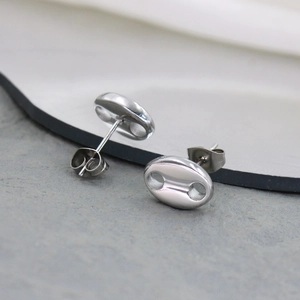 Macro detail of oval coffee bean stud earrings showing butterfly back and polished finish