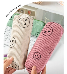 Detailed close-up of colorful corduroy pouches with signature heart smiley faces