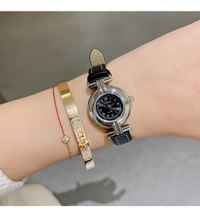 Close-up of vintage-style women's quartz watch with black leather strap and Roman numerals