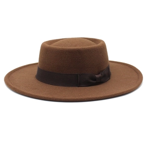 Detail of dark brown wool boater hat with matching ribbon and elegant bow decoration