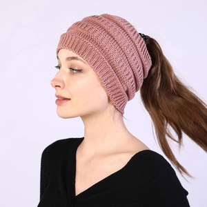 Close-up of pink knitted headband showing the ponytail hole design and soft wool texture