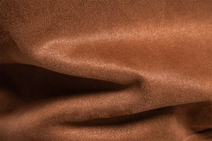 Vue macro du tissu suédine marron montrant la texture douce et le grain détaillé des fibres