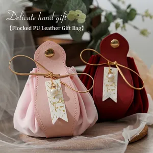 Elegant pink and red velvet PU leather wedding favor bags with gold accents and pearls