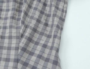Macro view of grey and white plaid fabric texture with precise stitching for dresses