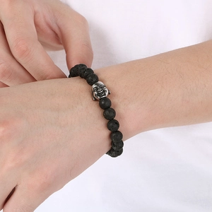 Close-up of 8mm black lava stone beads and silver Buddha head on an elastic bracelet