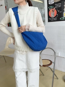 Minimalist blue crescent crossbody bag with pleated texture and adjustable strap