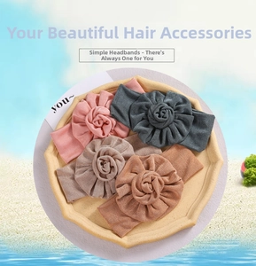 Set of four soft elastic baby headbands with large fabric flowers in neutral colors
