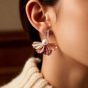 Gros plan de boucles d'oreilles vintage en éventail dorées avec zircon et perle
