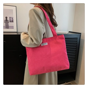 Detailed close-up of hot pink corduroy tote bag texture and fashion instinct label