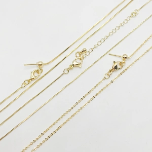 Macro shot of 14k gold adjustable chain textures with lobster clasp and bead detail