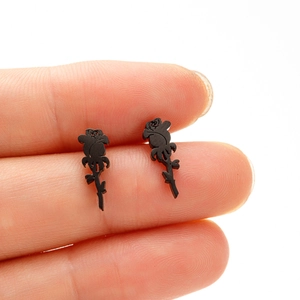 Detailed view of matte black rose earrings featuring a gothic flower design and small leaf