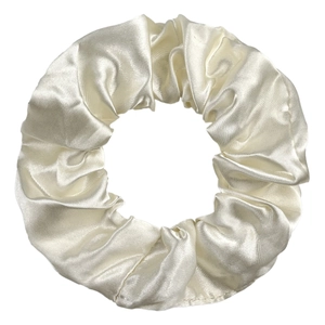 Detailed macro view of cream satin scrunchie showing fine fabric texture and silk shine