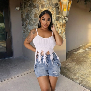 Women's summer knitted fringe crop top paired with distressed denim shorts