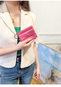 Close-up of pink leather envelope key pouch with zipper and snap button closure