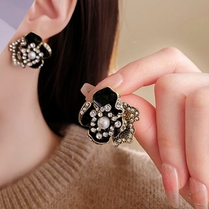 Detailed close-up of vintage flower earrings with central pearl and rhinestone halo