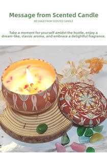 Close-up of a lit scented candle in a red tin with floral patterns on wood slice