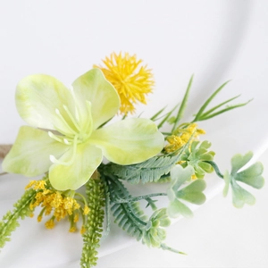 Green and yellow artificial wedding boutonniere floral decoration on white background