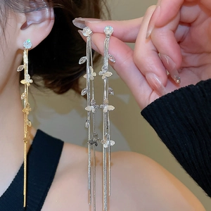 Vue détaillée de longues boucles d'oreilles papillon à pompons avec zircons brillants