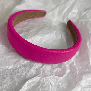Close-up of rose pink padded headband with lychee grain leather texture and soft inner lining