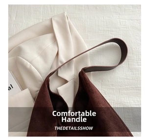 Detail of dark brown suede tote bag featuring a soft matte texture and wide handle